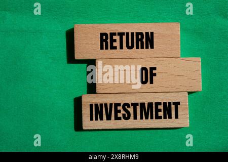 Return of investment words written on wooden blocks with green background. Conceptual return of investment symbol. Copy space. Stock Photo