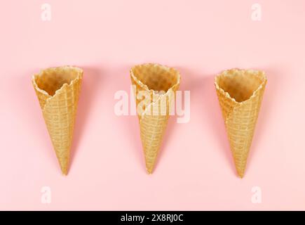 Top view of three ice cream waffle cones on pink background. Summer wallpaper, flat lay, copy space. Stock Photo