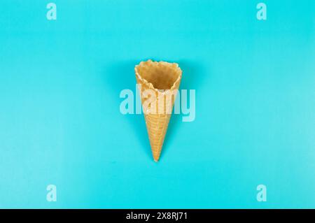 Top view of ice cream waffle cone on blue background. Summer wallpaper, flat lay, copy space. Stock Photo