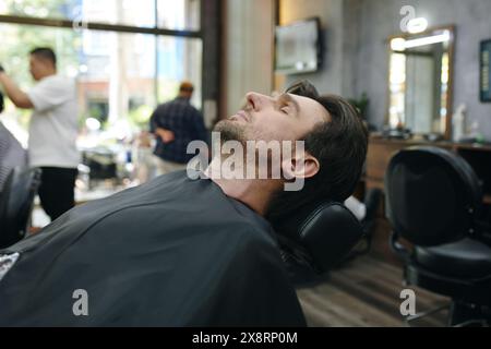 Man resting in styling chair waiting for barber Stock Photo