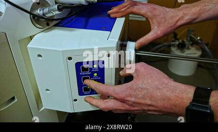Close up of worker adjusting 3D printer at the workshop. Stock footage. Industrial background at workshop. Stock Photo