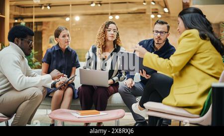 Multiethnic Group of People Brainstorming in a Conference Room at the Office. Successful Young Female Head of Operations Consulting Other Team Leads on a Future Project. Stock Photo