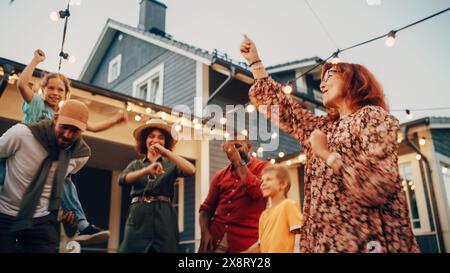 Diverse Multicultural Friends and Family Dancing Together at an Outdoors Garden Party Celebration. Young and Senior People Having Fun on a Perfect Summer Afternoon. Stock Photo