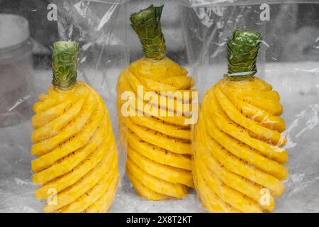 Ripe pineapple peeled in plastic bag selling in local market. Whole ripe pineapple peeled. Nobody, street photo Stock Photo