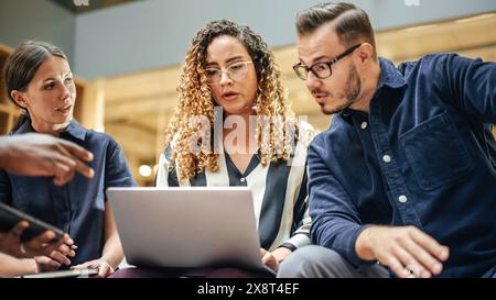 Wide Shot of a Multiethnic Group of People Discussing Ideas in a Meeting Room at Office. Businesspeople Making Creative Decisions For their Startup and Discussing Options Stock Photo