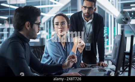 Team of Innovative Industrial Engineers Use Computer to Discuss a Technological Project in Industry 4.0 Modern Factory Office. Group of Scientists Work in Research and Development Center. Stock Photo
