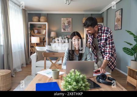 Young couple, freelancers small internet business owners, professional designers, computer software developers, working together at home, on new proje Stock Photo