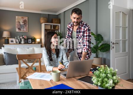 Young couple, freelancers small internet business owners, professional designers, computer software developers, working together at home, on new proje Stock Photo