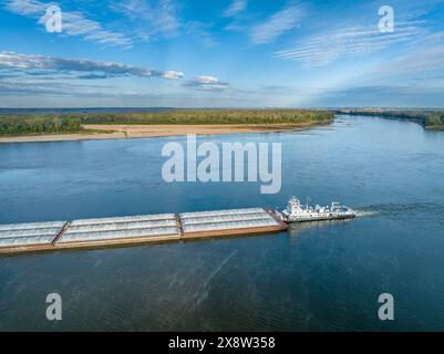 towboat with barges on the Mississippi River at confluence with the Missouri River below Alton, IL Stock Photo