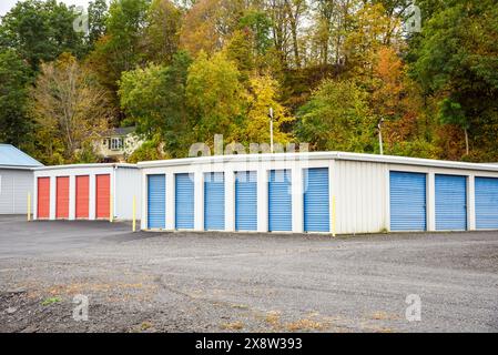 Self storage facility with a wooded hill in background in autumn Stock Photo