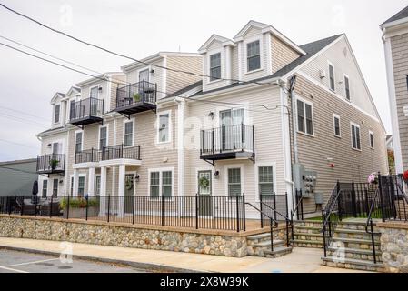 New terraced houses along a street in a housing development under cloudy sky in autumn Stock Photo