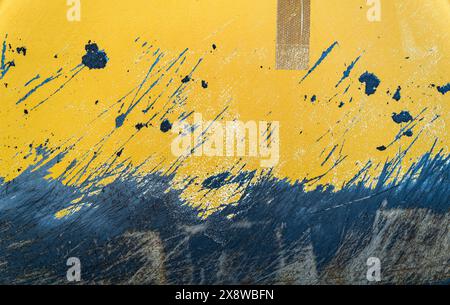The detail of the scratched surface of a metal plate painted yellow Stock Photo