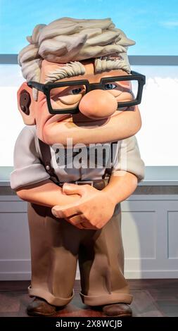 Madrid, Spain; 05-14-2024: Large figure of the character Carl Fredricksen, the old man from the animated movie Up, holding his cane with both hands in Stock Photo