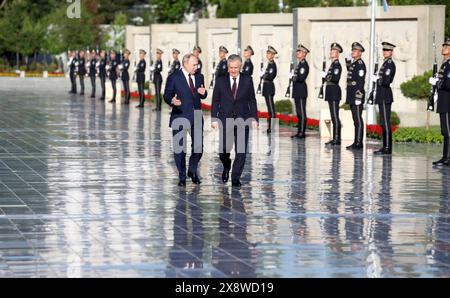 Tashkent, Uzbekistan. 27th May, 2024. Uzbek President Shavkat Mirziyoyev, right, escorts Russian President Vladimir Putin, left, following a flower ceremony at the Ode to Fortitude memorial of the Victory Park memorial complex, May 27, 2024, in Tashkent, Uzbekistan. The monument was erected in memory of Zulfiya Zakirova, an Uzbek mother who lost five sons during World War II. Credit: Mikhail Metzel/Kremlin Pool/Alamy Live News Stock Photo