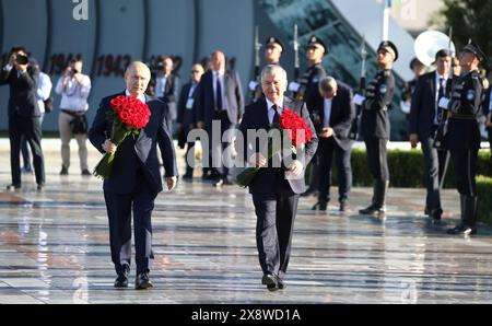 Tashkent, Uzbekistan. 27th May, 2024. Uzbek President Shavkat Mirziyoyev, right, escorts Russian President Vladimir Putin, left, during a flower ceremony at the Ode to Fortitude memorial of the Victory Park memorial complex, May 27, 2024, in Tashkent, Uzbekistan. The monument was erected in memory of Zulfiya Zakirova, an Uzbek mother who lost five sons during World War II. Credit: Mikhail Metzel/Kremlin Pool/Alamy Live News Stock Photo