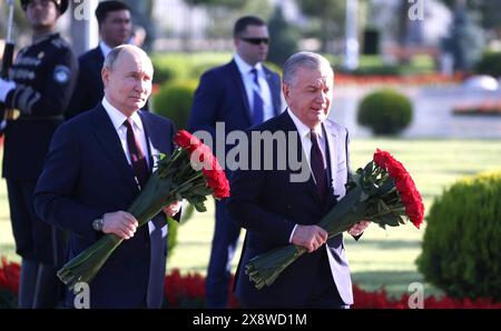 Tashkent, Uzbekistan. 27th May, 2024. Uzbek President Shavkat Mirziyoyev, right, escorts Russian President Vladimir Putin, left, during a flower ceremony at the Ode to Fortitude memorial of the Victory Park memorial complex, May 27, 2024, in Tashkent, Uzbekistan. The monument was erected in memory of Zulfiya Zakirova, an Uzbek mother who lost five sons during World War II. Credit: Mikhail Metzel/Kremlin Pool/Alamy Live News Stock Photo