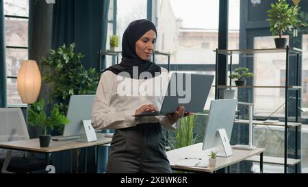 Islam businesswoman in hijab Arabian Indian muslim islamic woman business entrepreneur employer manager girl with laptop commerce working studying Stock Photo