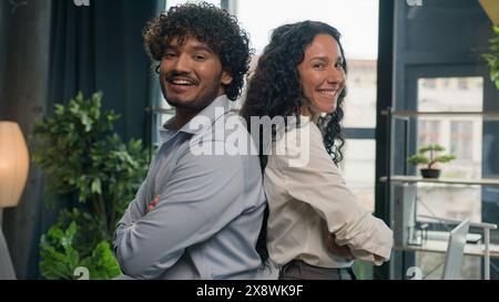 Two business partners multiracial colleagues Arabian man businessman and Hispanic woman businesswoman posing arms crossed in office diverse managers Stock Photo