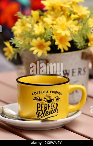 A bright yellow coffee cup sits on an outside table, Cadiz, Spain Stock Photo