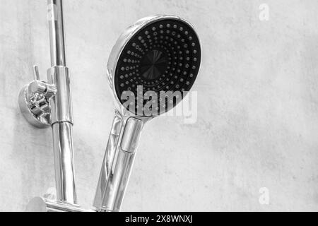 A shower head with a black nozzle is attached to a metal rod Stock Photo