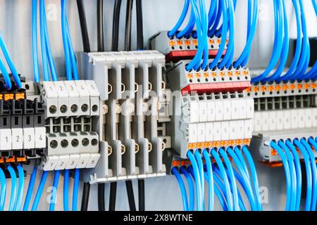 A blue and white electrical cable with a number of different colored wires. The cables are connected to a box with a number of different colored wires Stock Photo