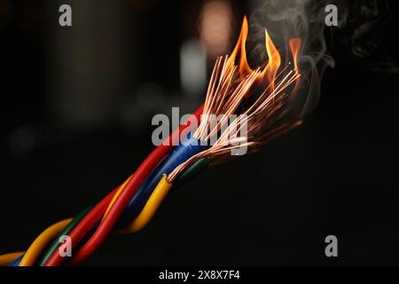 Electrical wire burning on dark background, closeup Stock Photo