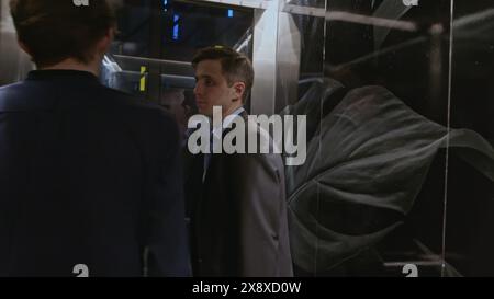 Team of start up businesspeople entering modern elevator and discussing corporate meeting. Stock clip. Businessmen using elevator to get to upper Stock Photo