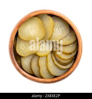 Burger gherkin slices, in a wooden bowl. Pickled cucumbers, cut in round cross sections, pasteurized and preserved in vinegar brine, with spices. Stock Photo