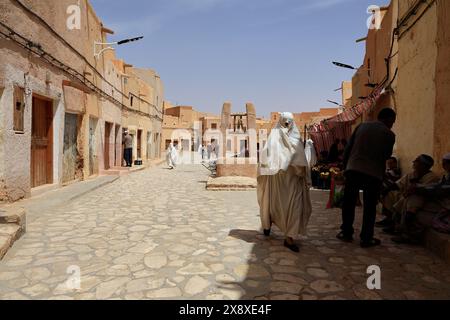 Veiled Mozabite women in white haik in market square of Ksar Beni Isguen.Beni Isguen is one of the 5 Ksars (fortified settlement) in Mzab valley.Ghardaia province.North Sahara.Algeria Stock Photo