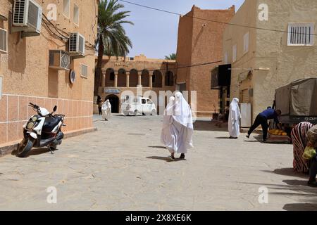 Veiled Mozabite women in white haik in market square of Ksar Beni Isguen.Beni Isguen is one of the 5 Ksars (fortified settlement) in Mzab valley.Ghardaia province.North Sahara.Algeria Stock Photo