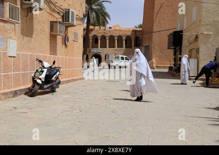 Veiled Mozabite women in white haik in market square of Ksar Beni Isguen.Beni Isguen is one of the 5 Ksars (fortified settlement) in Mzab valley.Ghardaia province.North Sahara.Algeria Stock Photo