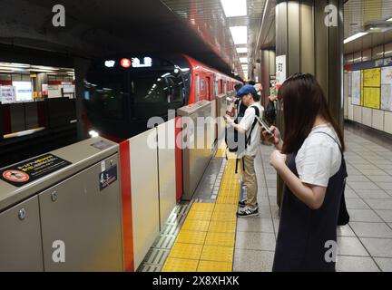 Passengers waiting for the metro train to Ikebukuro at the Jimbocho Station in Kanda, Tokyo, Japan. Stock Photo