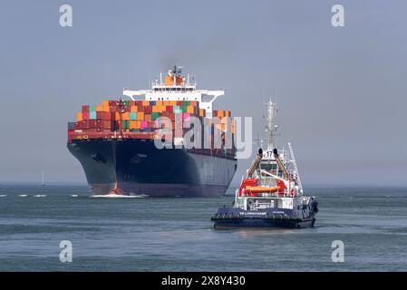 Le Havre, France - View on the harbour tug VB LONGCHAMP proceeding towards a vessel and container ship AL BAHIA arriving port of Le Havre. Stock Photo