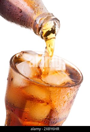 pouring cola into glass with ice from bottle isolated on white background Stock Photo