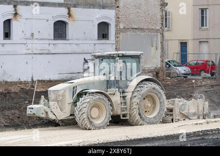 Nancy, France - Green tractor John Deere 8345R with a lime mixer for lime treatment of soil on a construction site. Stock Photo