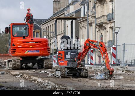 Nancy - View on a small red crawler excavator Kobelco SK10SR-2E with a bigger crawler excavator behind for the demolition of the old tramway platform. Stock Photo