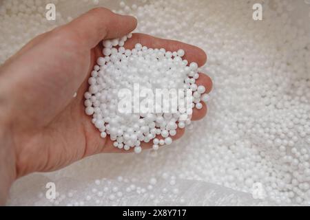 Polystyrene balls in hand. Packaging of fragile goods, filling for chair bags and pillows Stock Photo