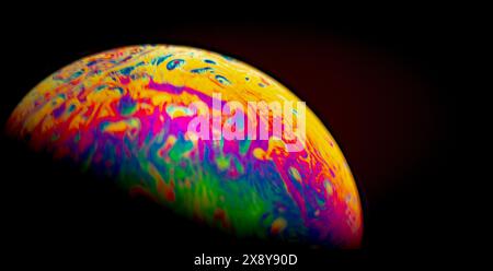 Virtual reality space with abstract multicolor psychedelic planet. Close up soap bubble like an alien planet on black background Stock Photo
