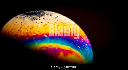 Virtual reality space with abstract multicolor psychedelic planet. Close up soap bubble like an alien planet on black background Stock Photo