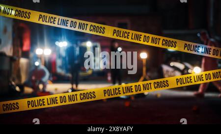 Crime Scene at Night: Crime Scene Investigation Team Working on a Murder. Female Police Officer Briefing Detective on the Victim's Body. Forensics and Paramedics Working. Cinematic Shot Stock Photo