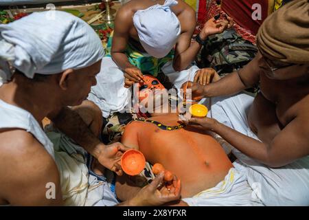 India, Kerala, Kannur, Theyyam ceremony. Beautifully dressed and with their faces painted entirely red, artists can take the form of multiple local de Stock Photo