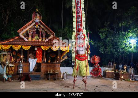 India, Kerala, Kannur, Theyyam ceremony. Beautifully dressed and with their faces painted entirely red, artists can take the form of multiple local de Stock Photo