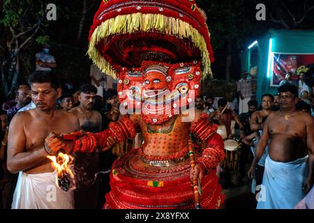 India, Kerala, Kannur, Theyyam ceremony. Beautifully dressed and with their faces painted entirely red, artists can take the form of multiple local de Stock Photo