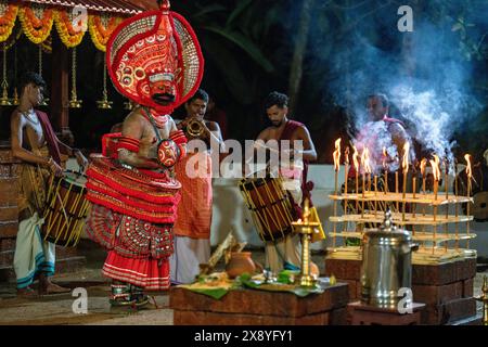 India, Kerala, Kannur, Theyyam ceremony. Beautifully dressed and with their faces painted entirely red, artists can take the form of multiple local de Stock Photo