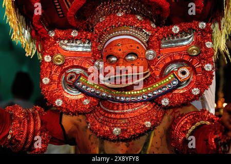 India, Kerala, Kannur, Theyyam ceremony. Beautifully dressed and with their faces painted entirely red, artists can take the form of multiple local de Stock Photo