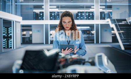 Portrait of a Beautiful Hispanic Female Wearing Glasses, Using Tablet Computer. Businesswoman, Information Technology Manager, Robotics Engineering Specialist. Stock Photo