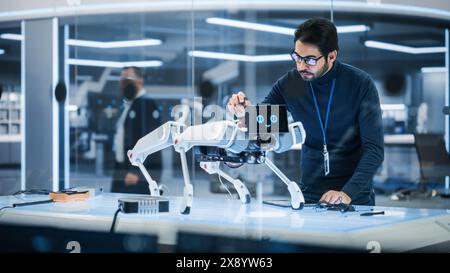 Portrait of Hispanic Engineer Using a Screwdriver While Building and Developing a Robot Dog Concept. Multiethnic Specialist Working in High Tech Research Laboratory with Modern Equipment. Stock Photo