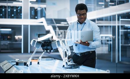 Handsome Black Man Wearing Glasses Using Laptop Computer. Young Intelligent Male Engineer or Scientist Working in Laboratory. Technology Office Background. Close Up Portrait. Stock Photo