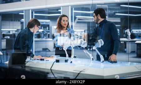 Young Team of Smart Diverse Multicultural Engineers Building and Developing a Robot Dog Concept. High Tech Research Factory with Talented Professional Employees. Stock Photo