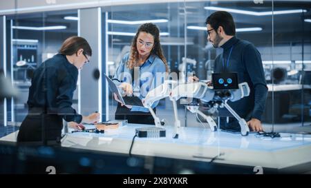 Young Team of Smart Diverse Multicultural Engineers Building and Developing a Robot Dog Concept. High Tech Research Factory with Talented Professional Employees. Stock Photo